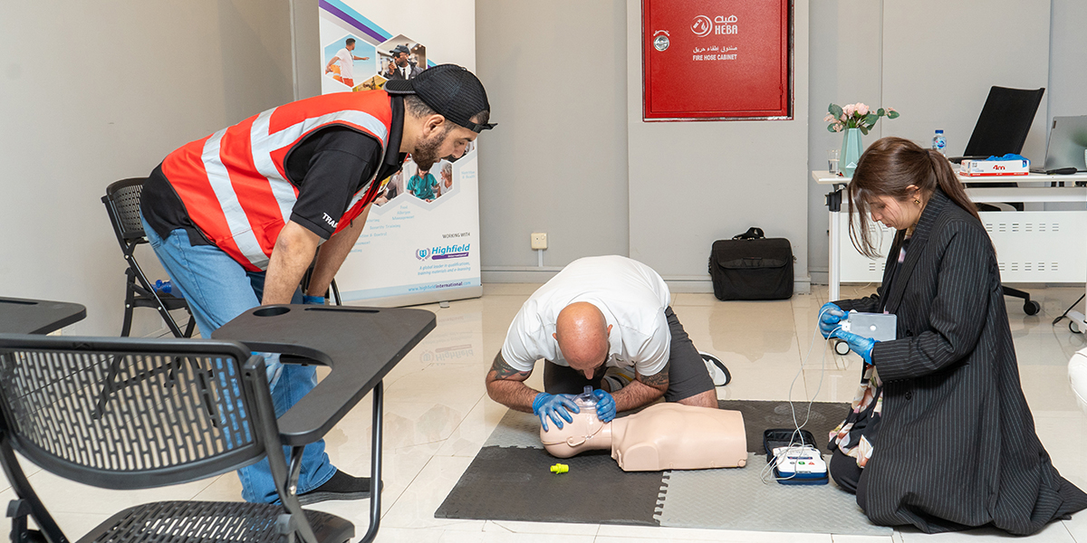 Employee performing first aid response during workplace training in Saudi Arabia